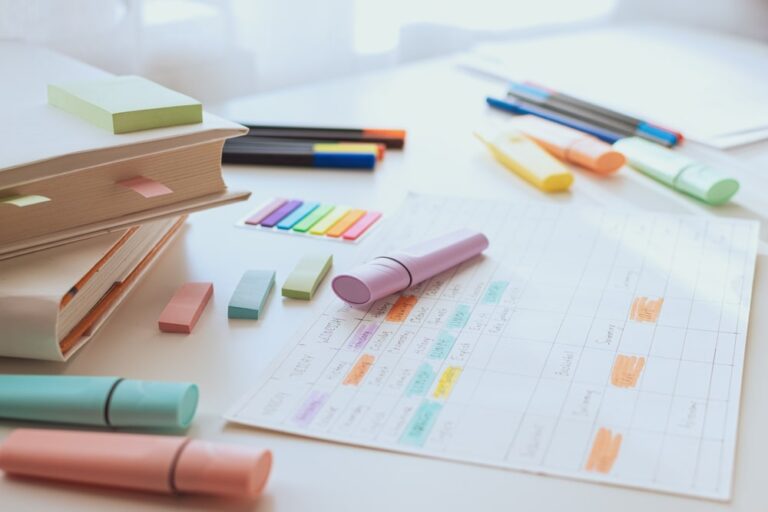 Mesa com canetas, cadernos e planner para fazer a organização da rotina.