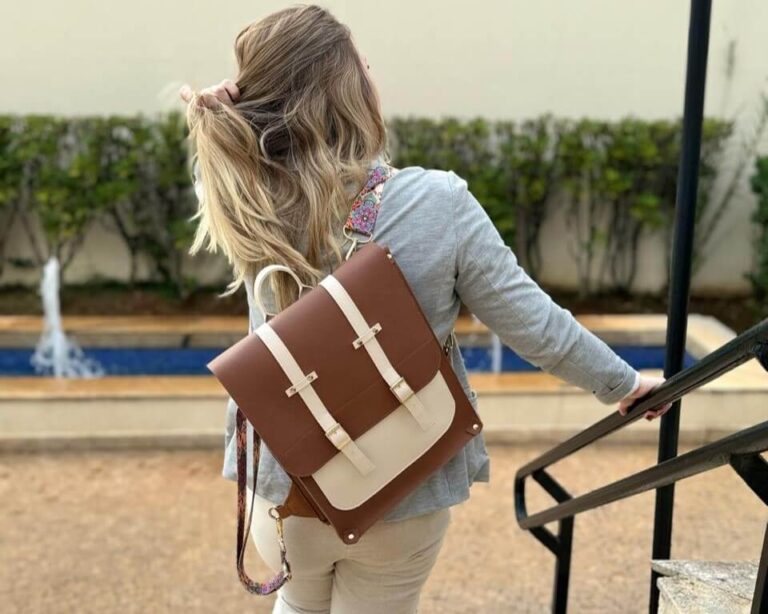 Foto da Grazi Sá usando uma mochila para trabalho na cor marrom com detalhes bege.